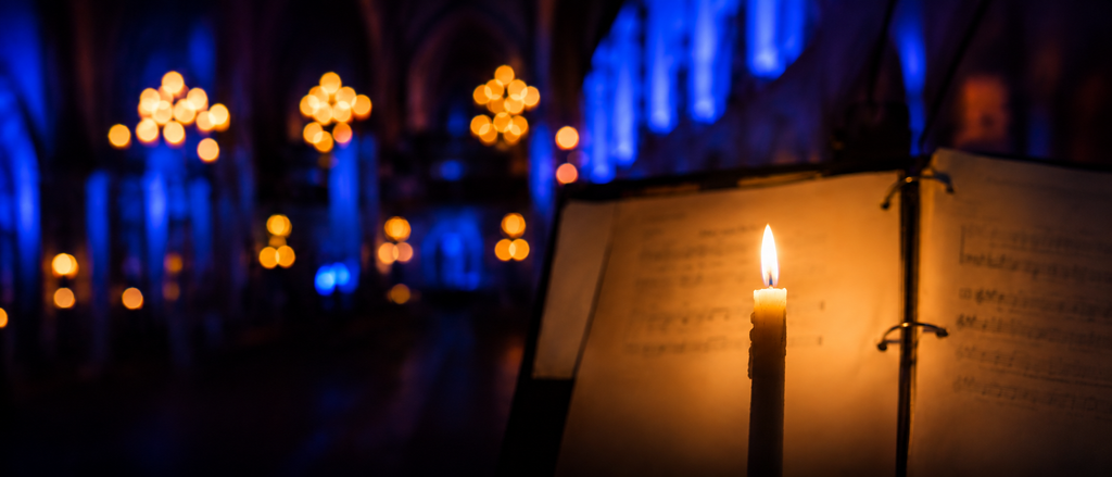 Lit candle beside softly blurred sheet music during Candlelit Contemplative worship at St. Andrew’s-Wesley United Church in Vancouver.